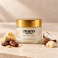 Bálsamo labial de cacao y karité de maro naturals, frasco lleno con tapa dorada junto a cacao, coco y mantecas.