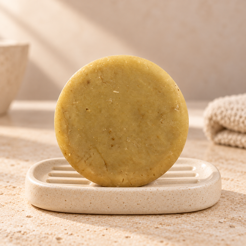 Imagen complementaria generada con IA del shampoo sólido Café y Romero de maro naturals sobre una jabonera en un baño.