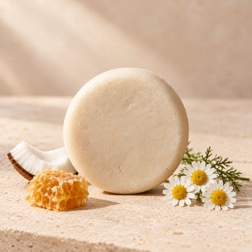 Shampoo sólido de coco, miel y manzanilla de maro naturals, barra clara junto a coco, miel y flores de manzanilla.